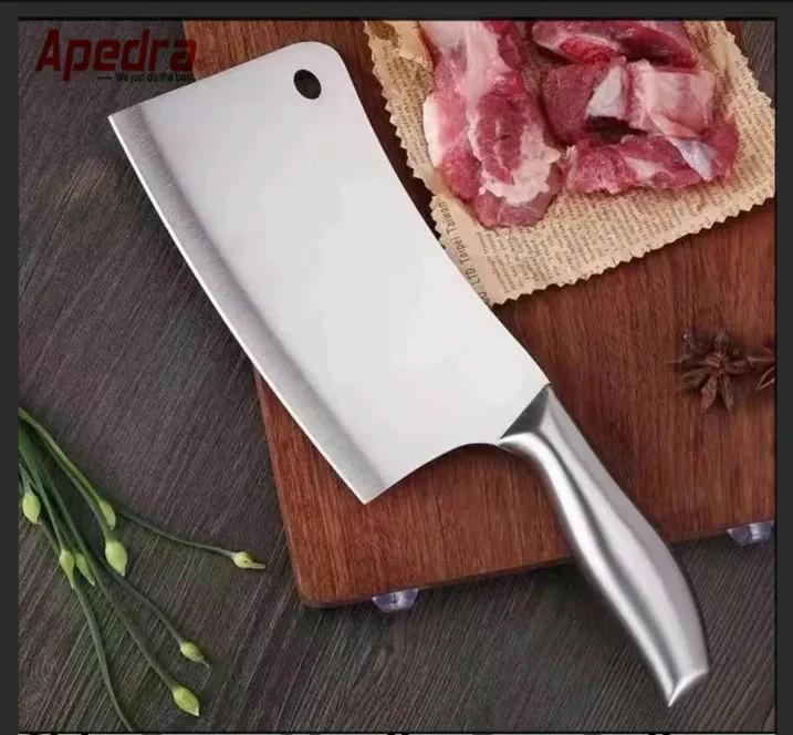 Knife on a wooden cutting board with chopped meat in the background