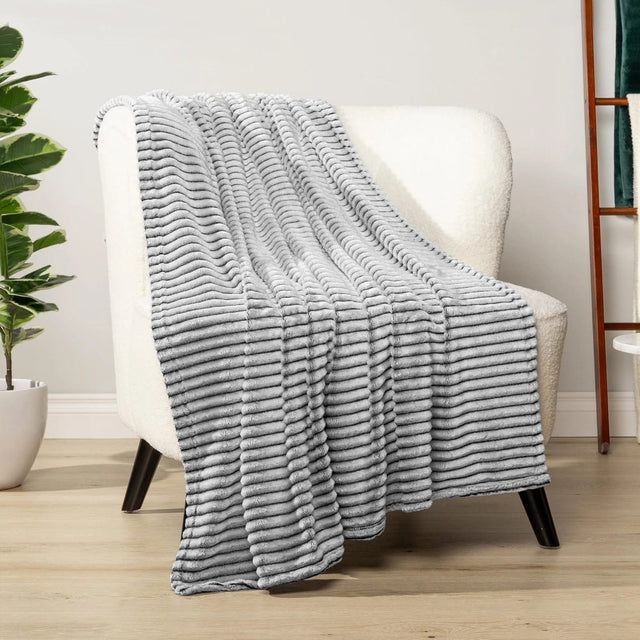 Grey: Ribbed fleece blanket grey flannel draped on armchair living room — iDecorators Kenya