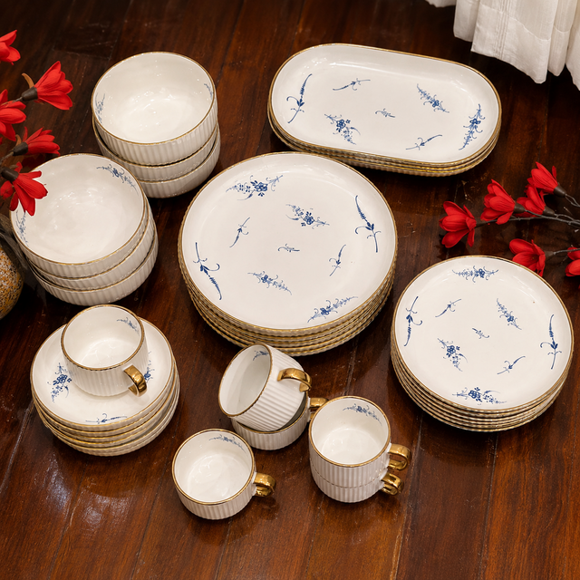 32-piece white ceramic dinner set with blue floral design and gold trim including plates, bowls, cups, saucers and serving platters