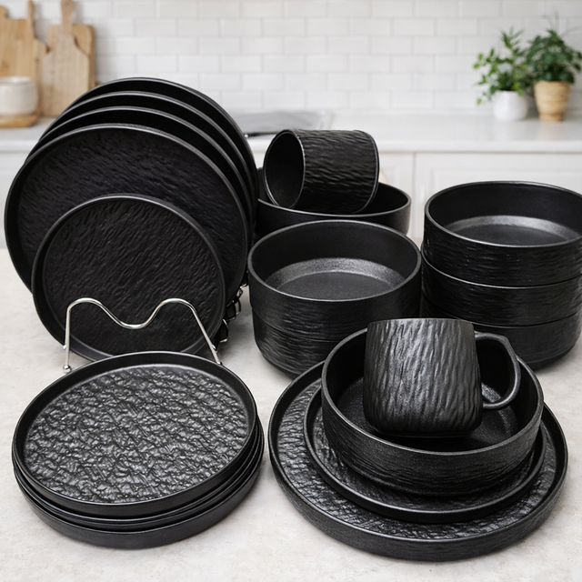 Set of black ceramic dinnerware on a kitchen counter