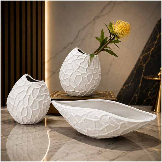 Modern white textured ceramic vase set with matching decorative bowl displayed on a marble tabletop.