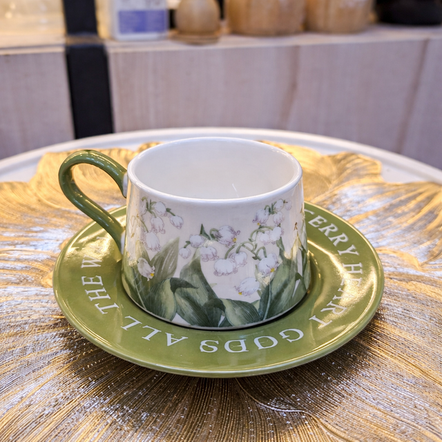 Cup and saucer with floral design on a wooden table