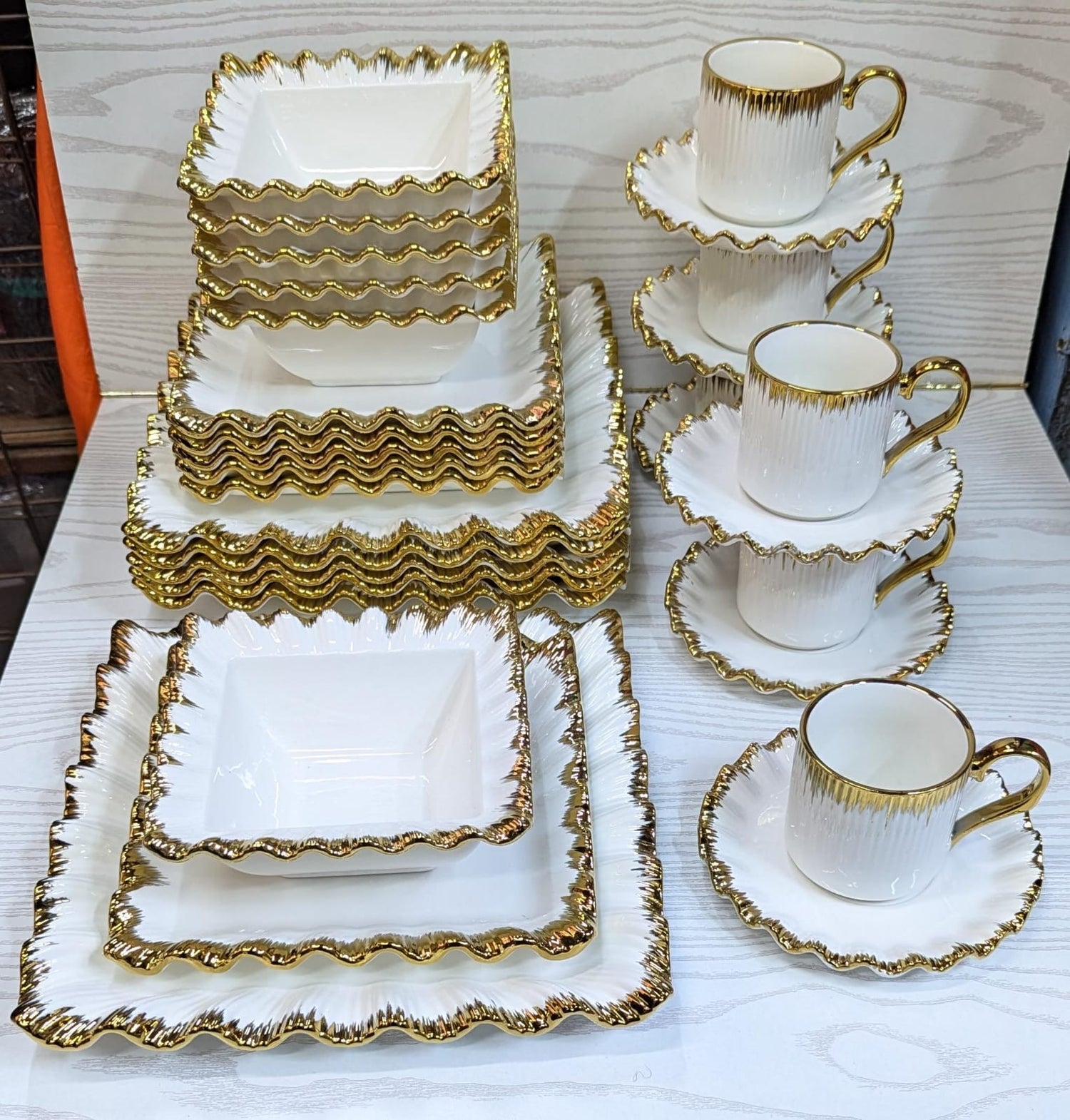 Material: Made from high-quality ceramic, offering strength and durability for everyday use and special occasions.
Design: Square-shaped plates and bowls with a sleek, modern finish that adds elegance to any dining setting.
Detailing: Each piece features a refined gold rim, giving a luxurious and classic appearance.
Set Includes: 6 dinner plates, 6 side plates, 6 soup bowls, 6 dessert bowls, and 6 mugs – ideal for a full table setting.
Color Scheme: Typically comes in white or ivory base to contrast bea