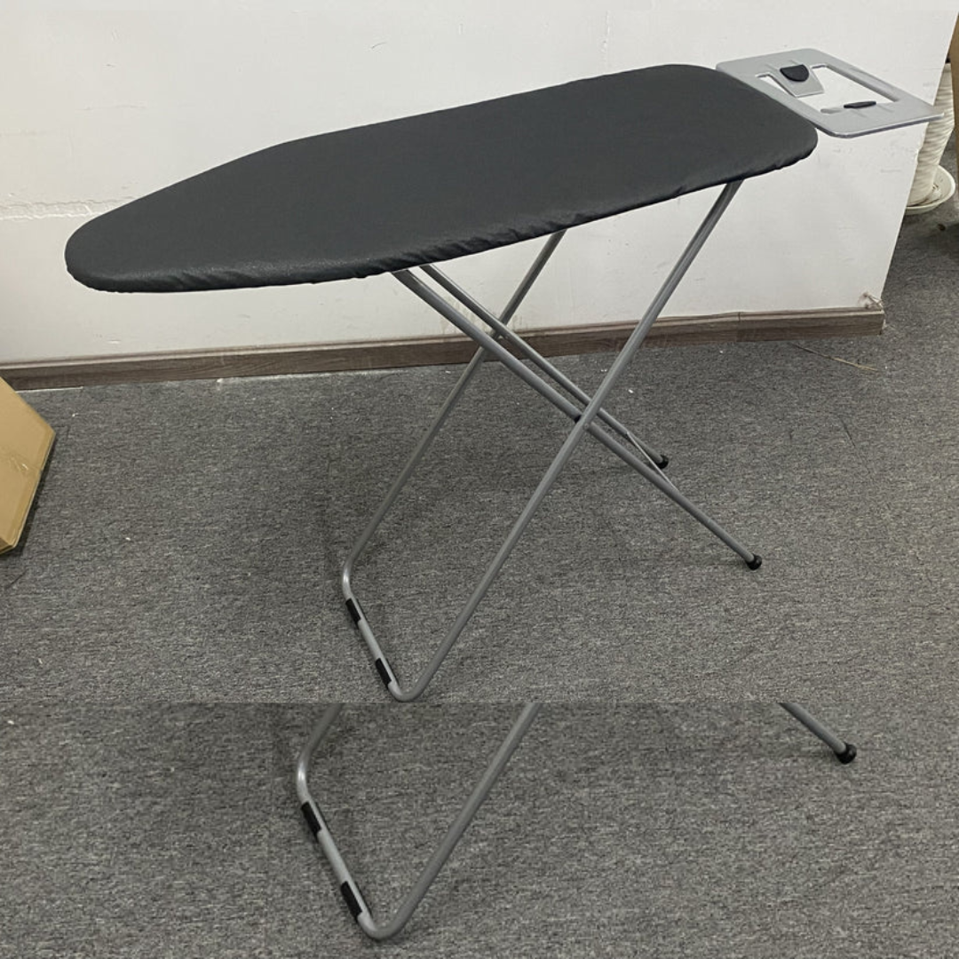 A full-size ironing board with a black, chevron patterned removable cover, and a gray steel frame with four legs.