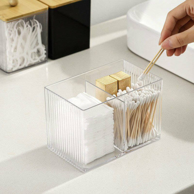 An acrylic makeup organizer with three compartments, storing cotton pads, swabs, and a bamboo lid on the side.