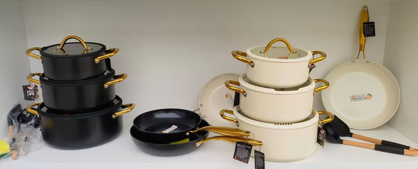 UCC Life 11-piece ceramic marble non-stick cookware set in matte black and cream white with gold handles, glass lids and silicone utensils on shelf