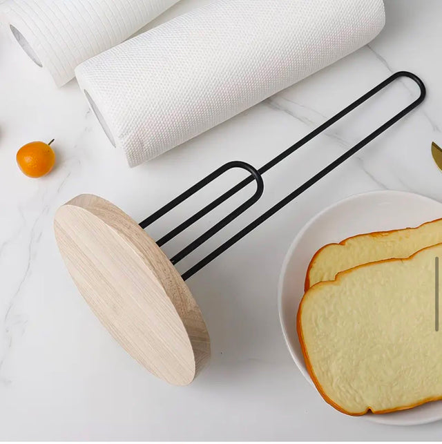Kitchen paper towel holder with wooden base and black metal frame for countertop paper towel roll storage.