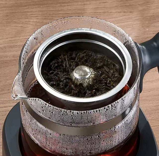 Chigo smart electric health pot and tea maker with LED digital display, glass carafe and stainless steel infuser on wooden table with tea cups
