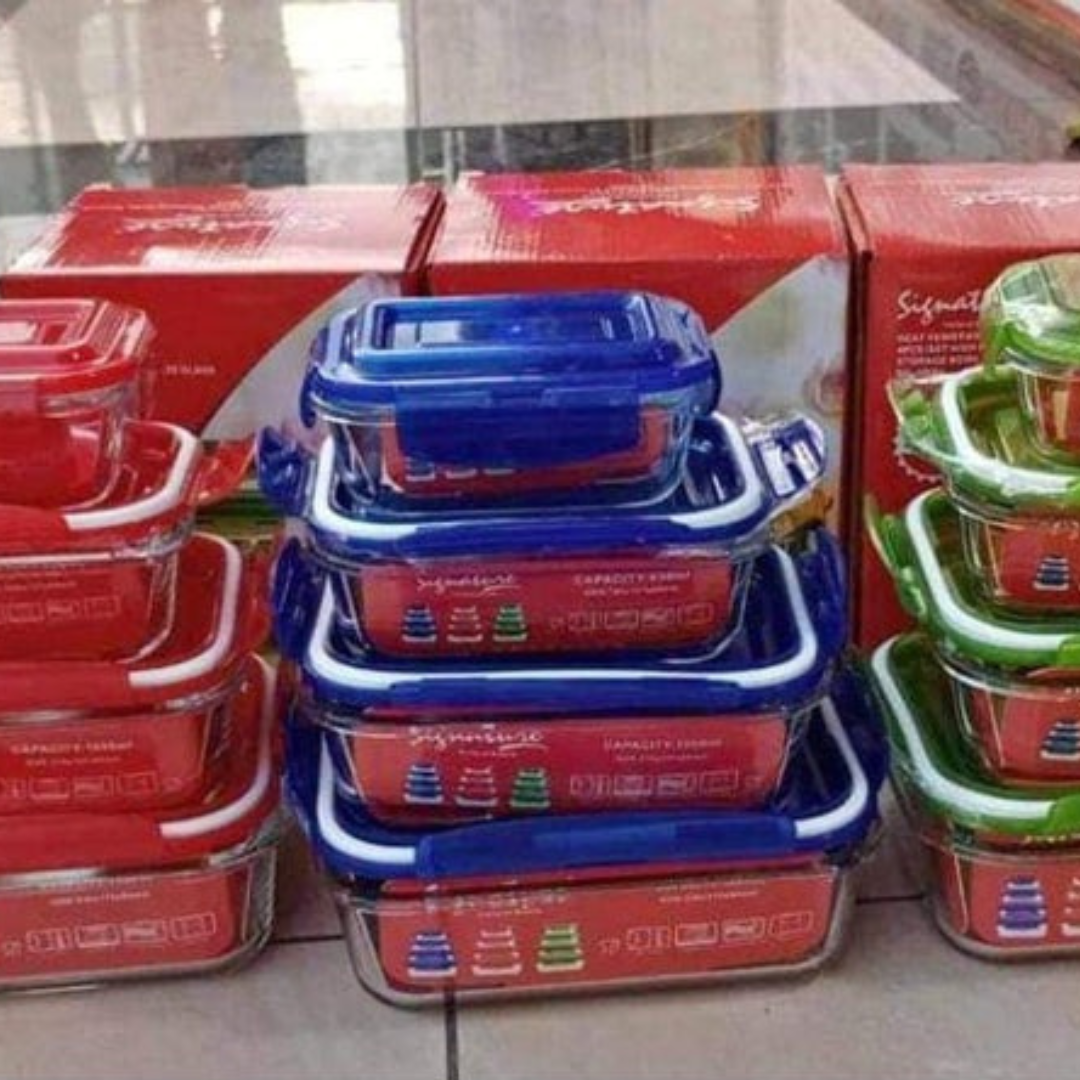 Stacked borosilicate glass casseroles with blue lids, in varying sizes, displayed in red boxes.