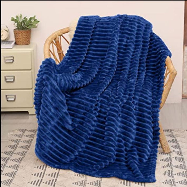 Navy Blue: Ribbed fleece blanket navy blue flannel draped on rattan chair — iDecorators Kenya