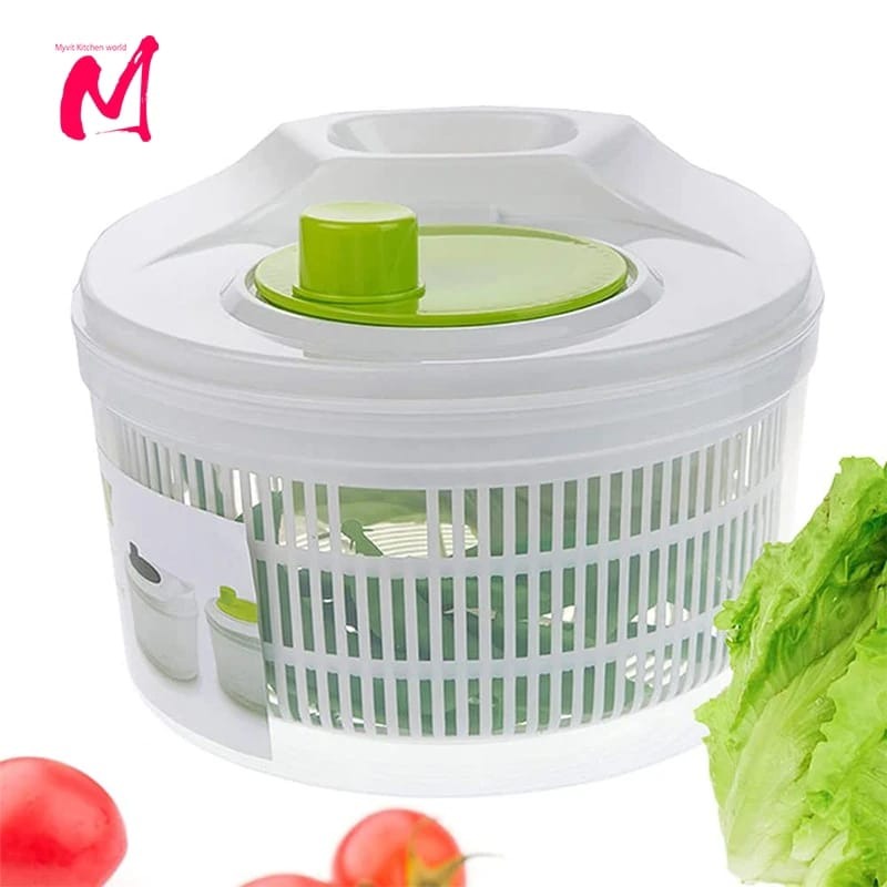 A white salad spinner with a green lid, displayed with tomatoes and lettuce leaves around it.