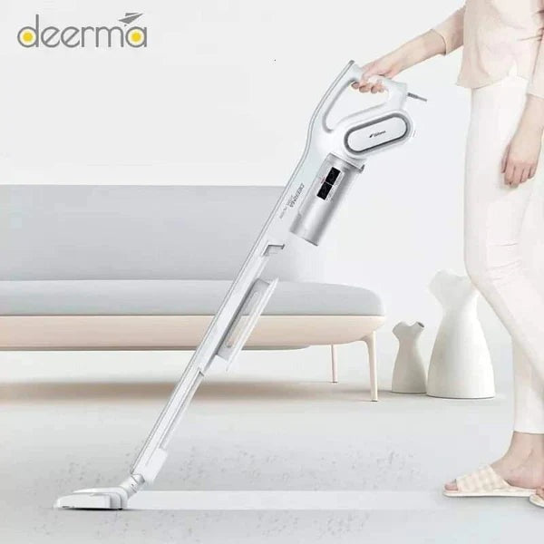 A Deerma handheld vacuum cleaner in white color being used on a floor, depicted in a photo with a person standing beside it.