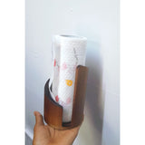 Walnut brown wooden freestanding paper towel holder measuring 15cm tall by 10cm wide, with curved cylindrical body, black metal spindle and open front slot, holding a white tissue roll on a kitchen countertop — available at iDecorators Kenya, Nairobi.