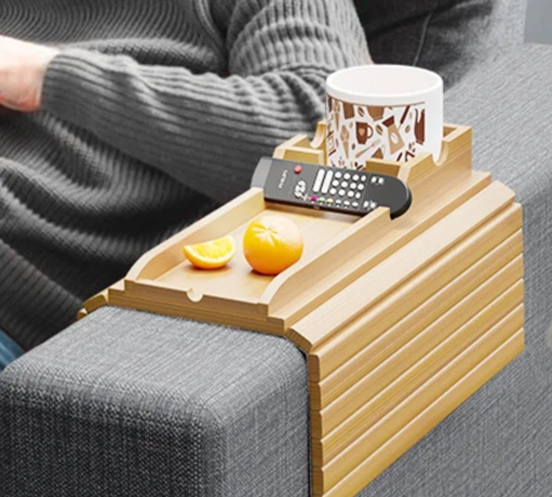 
Foldable natural bamboo sofa armrest tray measuring 16.3 by 13.3 inches with 5.1-inch built-in cup holder box, phone slot and flat surface for remote and snacks, shown clipped over a grey couch arm with a mug and TV remote — available at iDecorators Kenya, Nairobi.