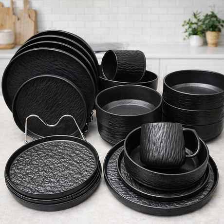 Set of black ceramic dinnerware on a kitchen counter