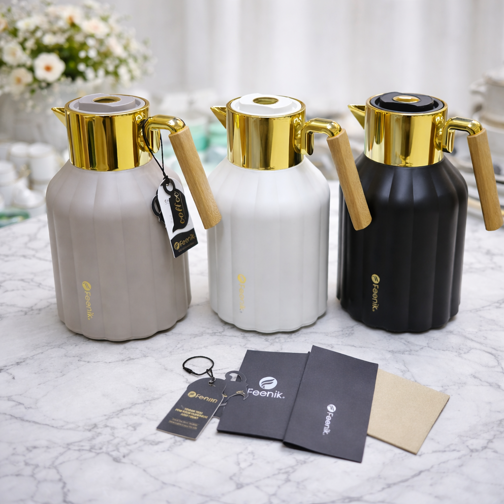 Three thermos bottles with gold lids and handles on a marble surface, with 'Feenik' branding visible.