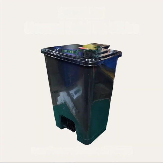Black and green trash bin on a white background