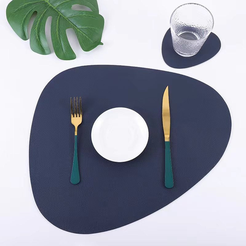 Navy blue placemat with white plate, gold fork, and knife on a white background
