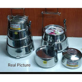 Set of stainless steel containers with lids on a white surface against a wooden background.