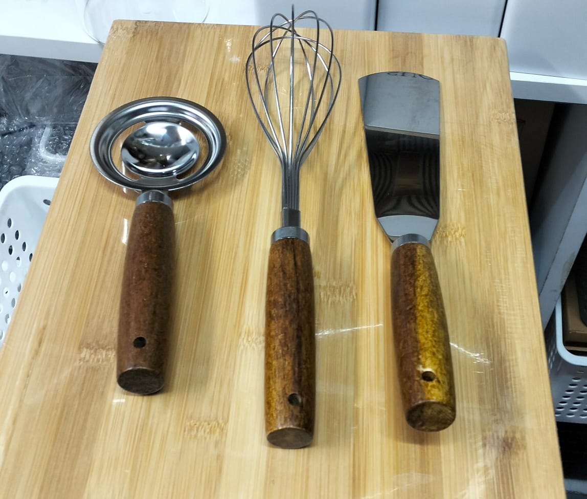 Stainless kitchen accessories with wooden handles.