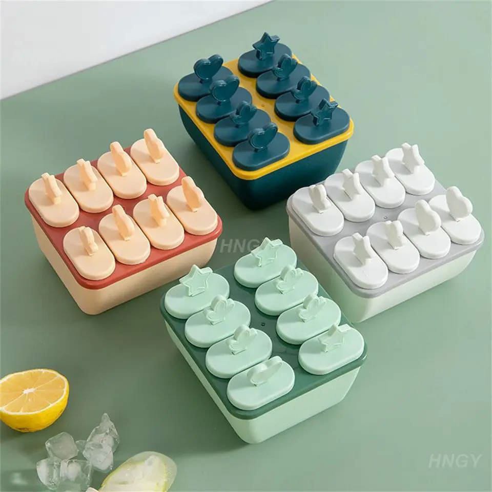 A set of silicone popsicle molds in various solid colors, including red, blue, green, yellow, and white, displayed with a lemon and ice cubes in the background.