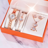 Rose gold jewelry set including a watch, bracelet, and earrings in an orange box.