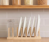 Natural bamboo wooden plate rack stand with 7 upright rod slots holding white ceramic dinner plates vertically on a kitchen counter, shown with easy 4-step no-tool assembly — dish drying and storage organiser available at iDecorators Kenya, Nairobi.