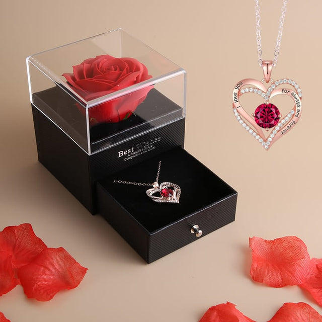 Jewelry set with heart-shaped pendant and red rose in a box on a beige background