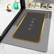 Gray doormat with 'HOME' text on a bathroom floor