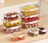 Set of clear food storage containers with various food items on a wooden surface.