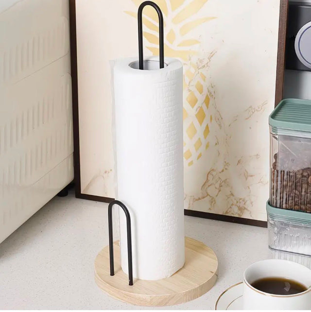 Paper towel holder on a kitchen counter with a coffee cup and container in the background.
