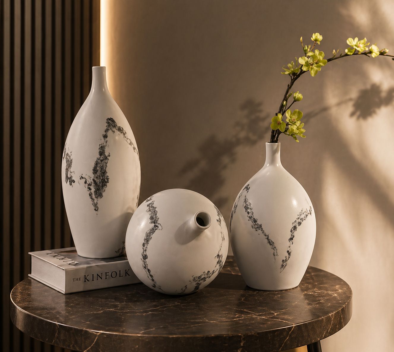 Three glossy white ceramic decorative vases with curved silhouettes in different sizes displayed on a modern table.