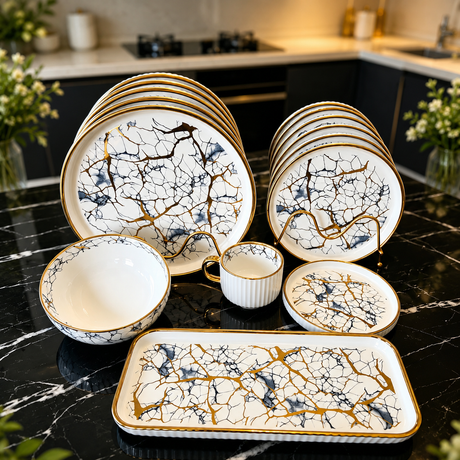 30-piece marble pattern porcelain dinner set with gold rims, featuring dinner plates, side plates, soup bowls, cups, saucers, and serving platter on a black marble countertop.
