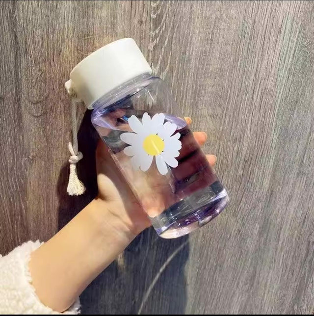 Transparent 450ml reusable water bottle with white leak-proof lid, daisy flower print, and carry strap for everyday hydration.