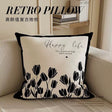 Decorative pillow with tulip design and 'Happy life' text on a couch.