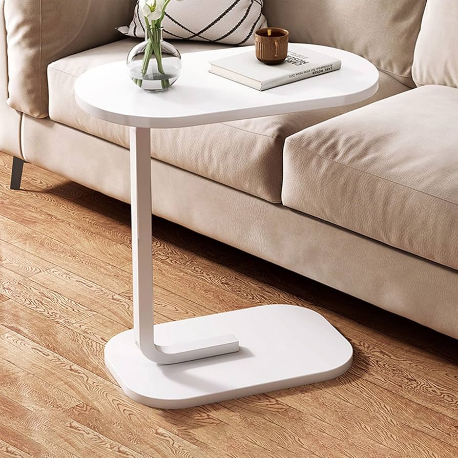 White side table with a small round top next to a beige sofa on a wooden floor.
